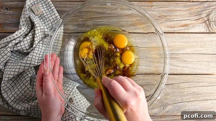 Whisking ingredients together for pecan pie bars.