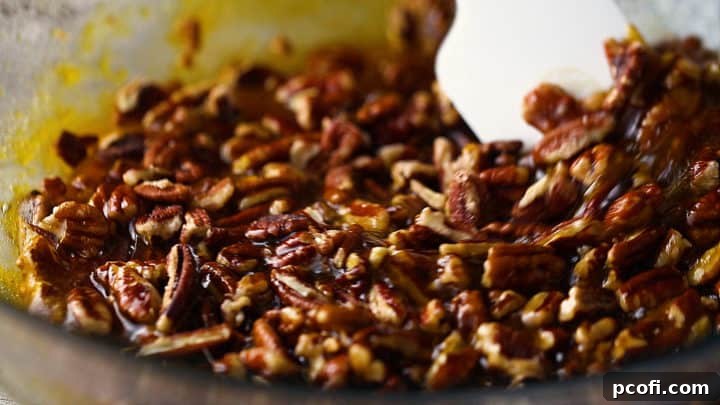 Folding chopped pecans into pecan bars filling.