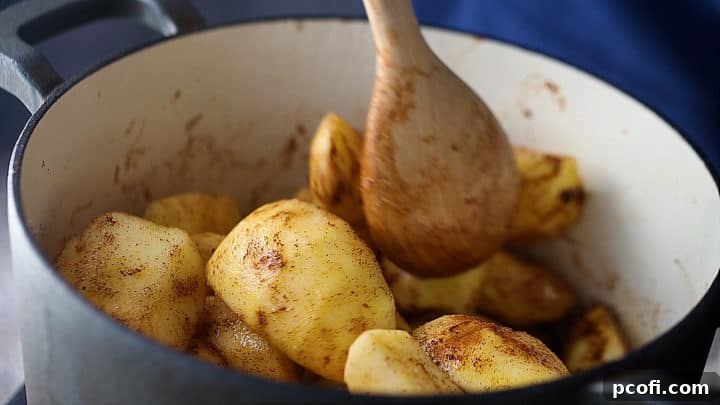 Stirring applesauce ingredients together in a pot with a wooden spoon.