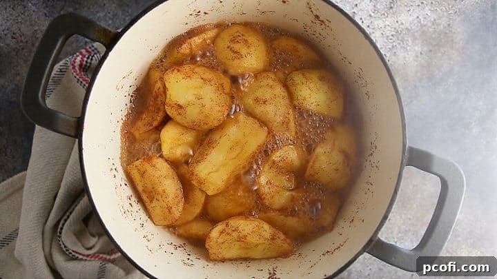 Homemade applesauce simmering in a pot on the stovetop.