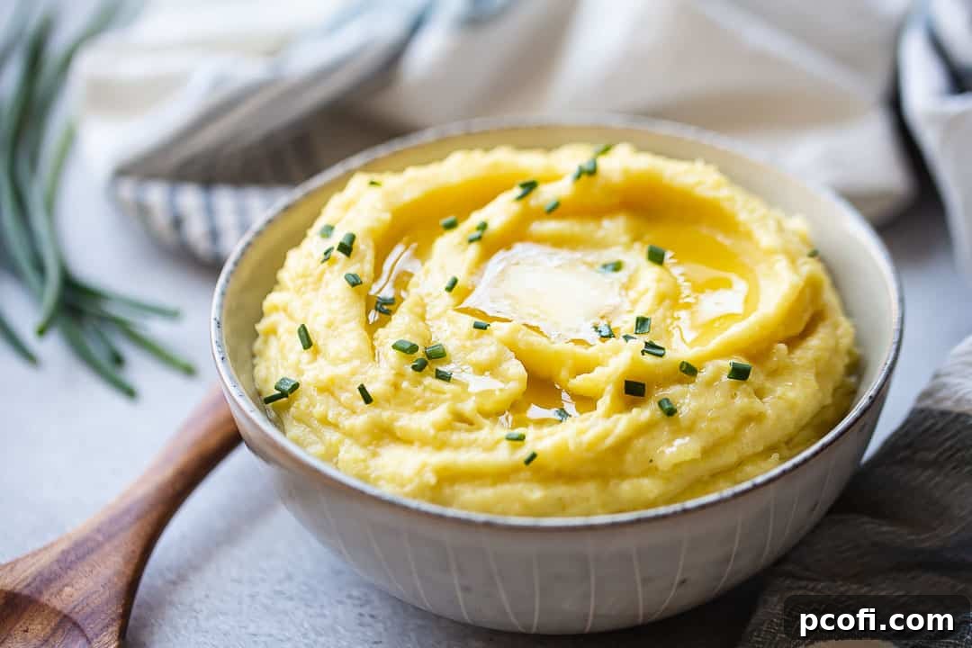Buttery, fluffy mashed potatoes in a large serving bowl with a wooden spoon, ready to be enjoyed.