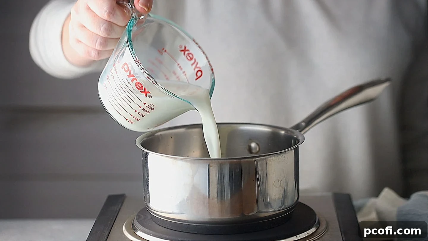 Milk and cream being gently warmed together in a small pot over a low flame.