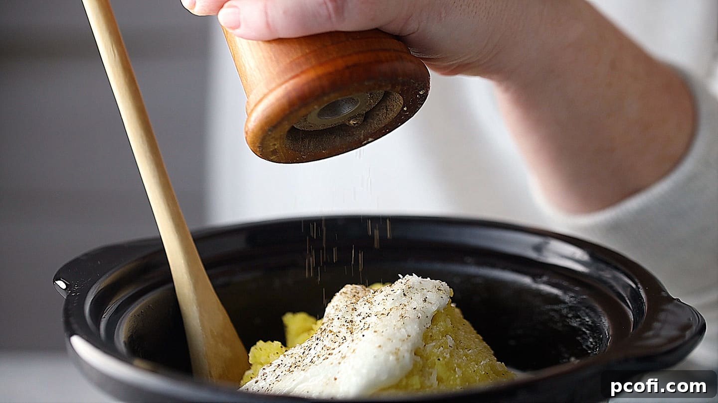 Finishing mashed potatoes with a sprinkle of freshly ground black pepper.
