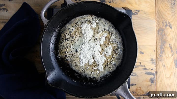 Creating a roux by cooking butter and fat with flour in a pan.