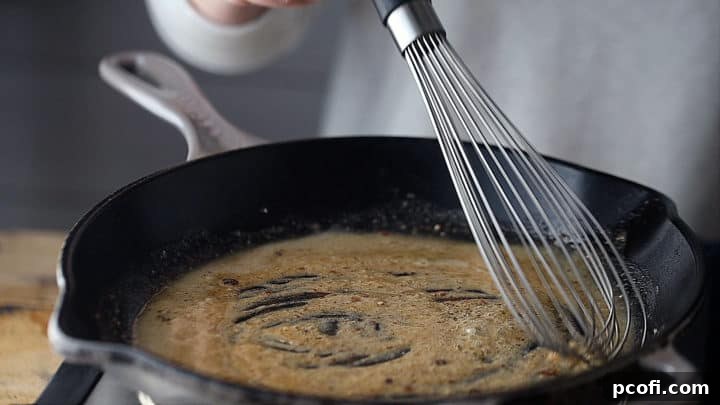 Browning the flour and fat mixture (roux) in a stainless steel skillet.