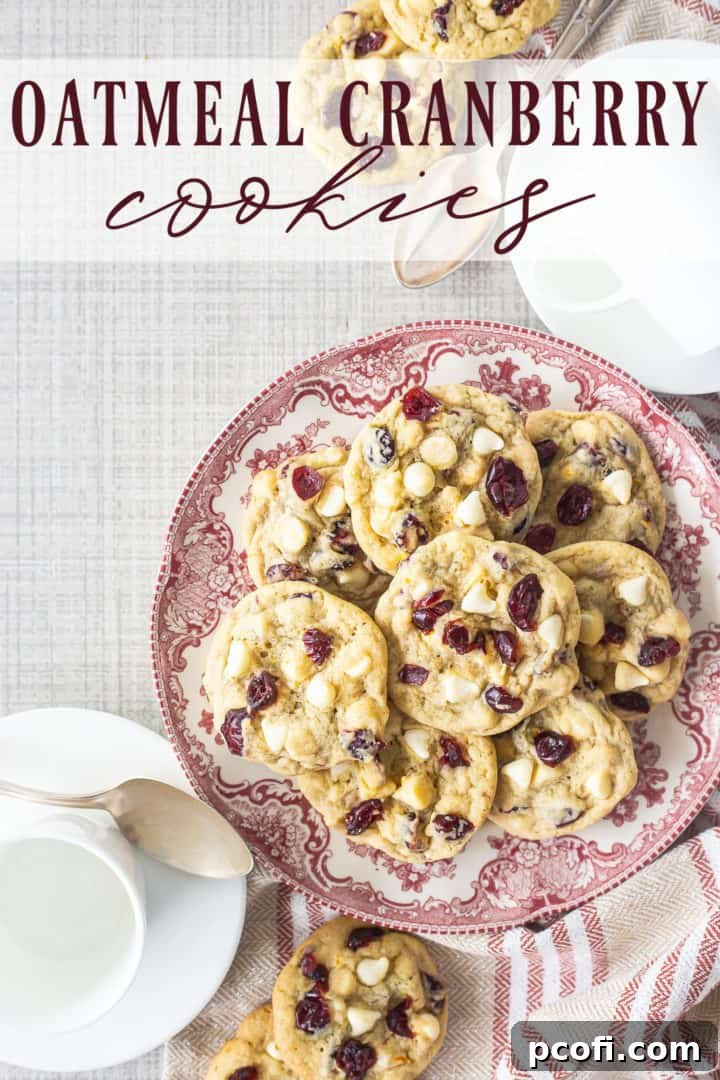An overhead shot showcasing a plate piled high with golden-brown oatmeal cranberry cookies, with a tempting visual appeal.