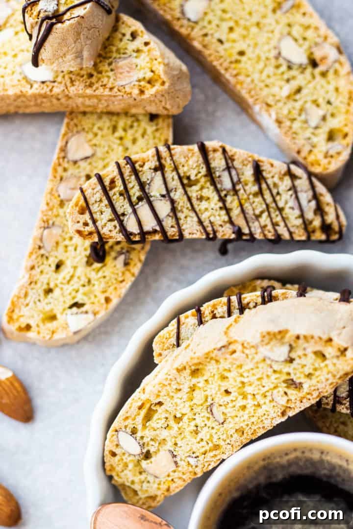 Overhead image of biscotti cookies scattered on a pale gray background.