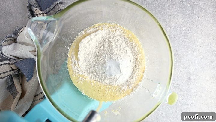 Adding dry ingredients to the egg and sugar mixture.