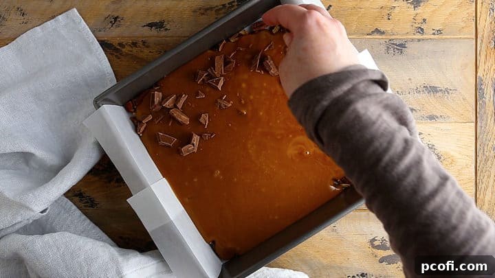 Sprinkling finely chopped chocolate over the hot, freshly poured toffee in the pan.