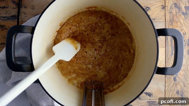 The toffee mixture cooking and caramelizing to a rich peanut butter-like color, indicating progress towards the hard crack stage.