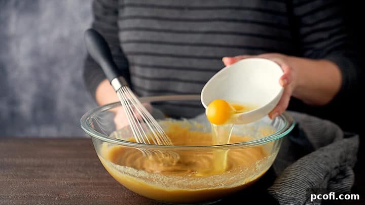 Whisking eggs into peanut butter blondie batter.