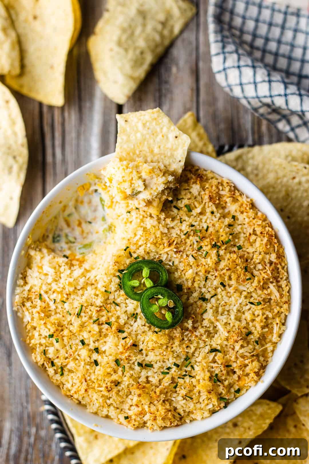 Overhead image of jalapeno popper dip with bacon, surrounded with corn chips.