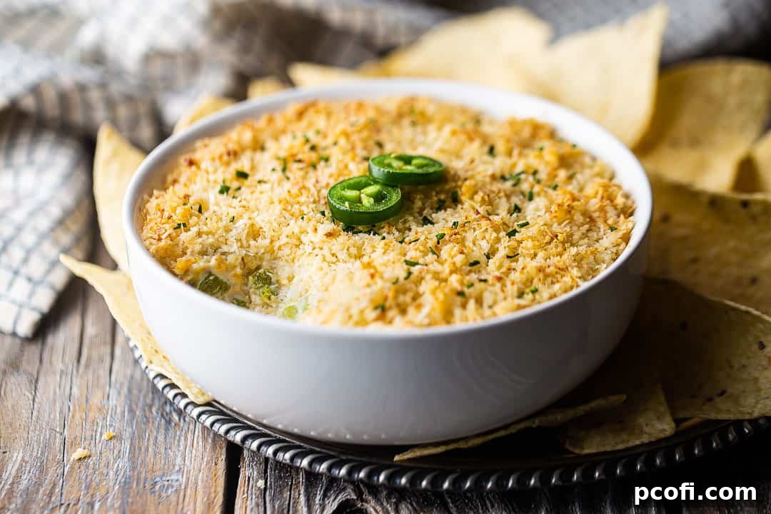 Jalapeno popper dip crock pot transferred to a serving dish and garnished with fresh jalapenos.