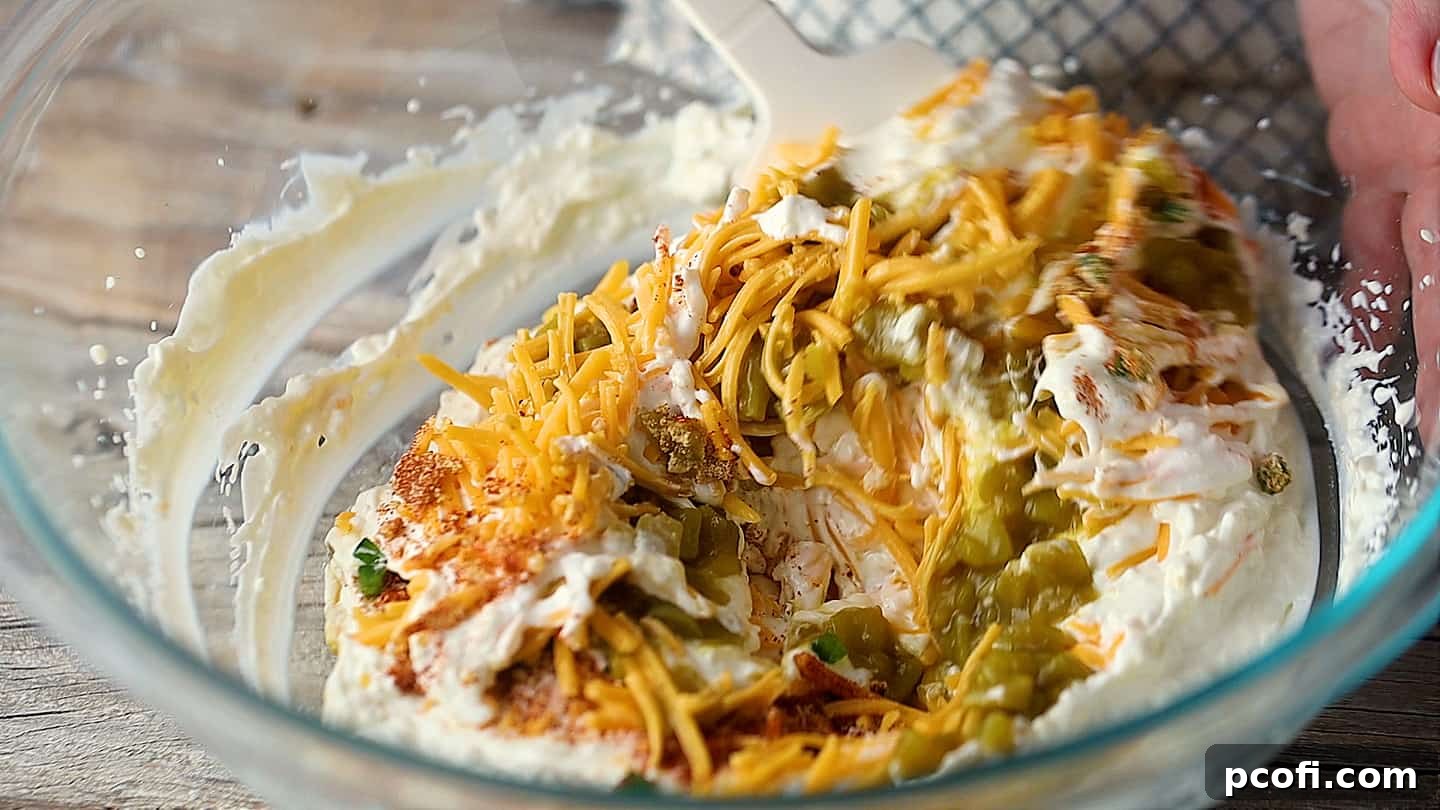 Folding jalapeno popper dip together until combined.