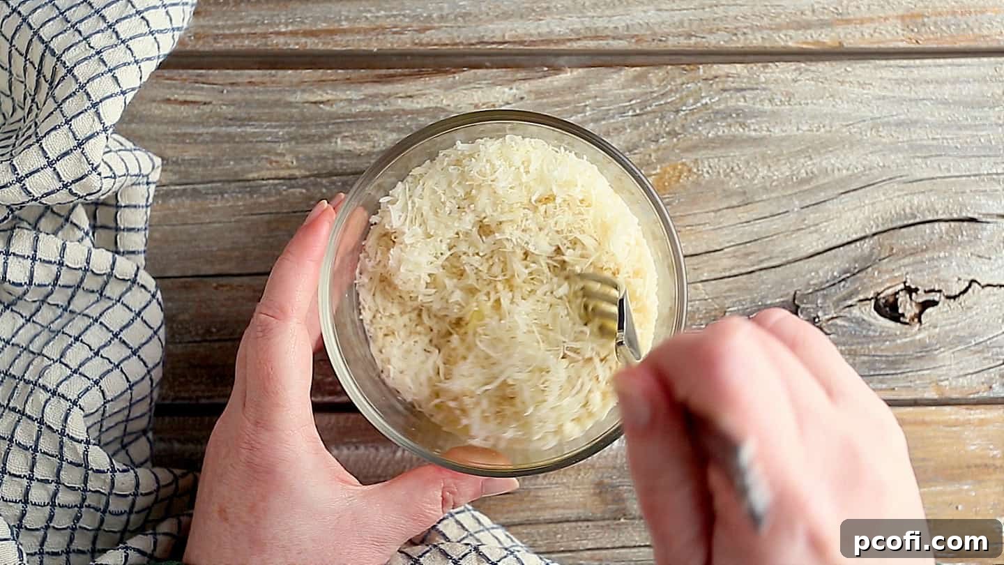 Stirring breadcrumb mixture together in a small bowl.