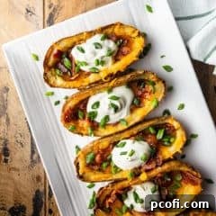 Potato skins served on a white rectangular platter.