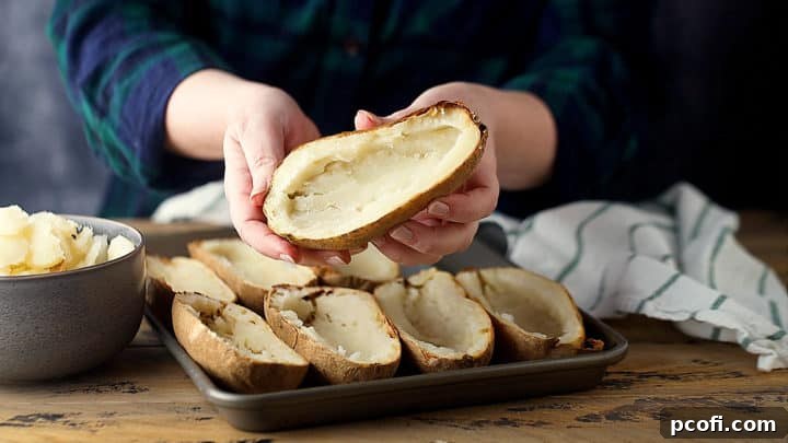 Baked potatoes, perfectly halved lengthwise and expertly scooped out, leaving a sturdy shell.