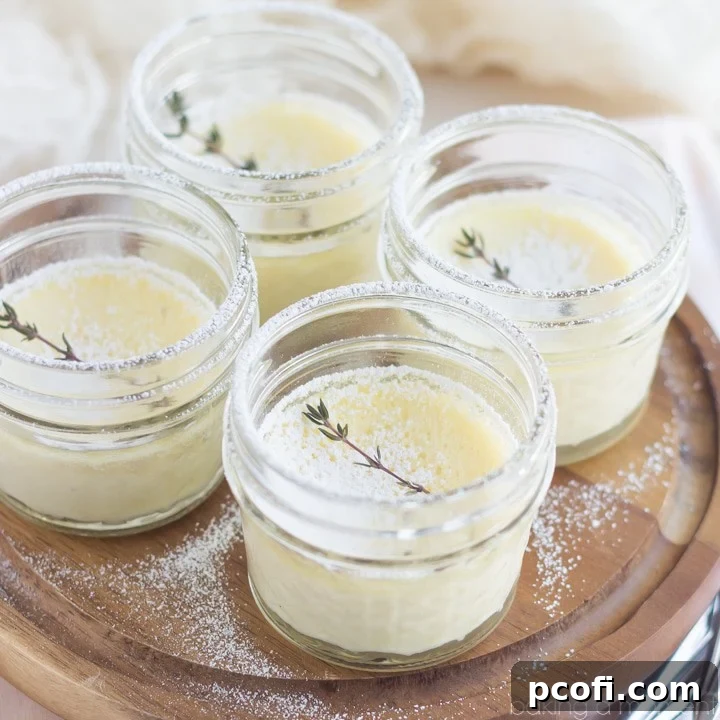 A beautifully presented Meyer Lemon and Thyme Pot de Creme in a small glass jar, garnished with a sprig of fresh thyme and a dusting of powdered sugar.