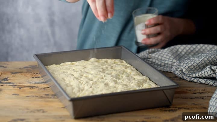 Sprinkling unbaked focaccia with sea salt.