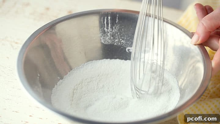 A bowl shows granulated sugar, cornstarch, and salt being whisked together, creating a fine, uniform mixture.