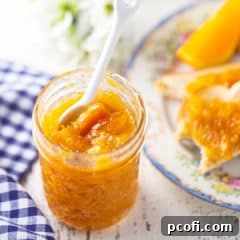 Marmalade in a glass jelly jar with a white ceramic spoon, used as the featured image for the recipe card.