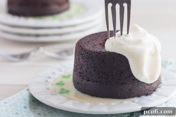 Mini bundt cakes arranged on a serving plate with a bowl of Irish Whiskey Hard Sauce