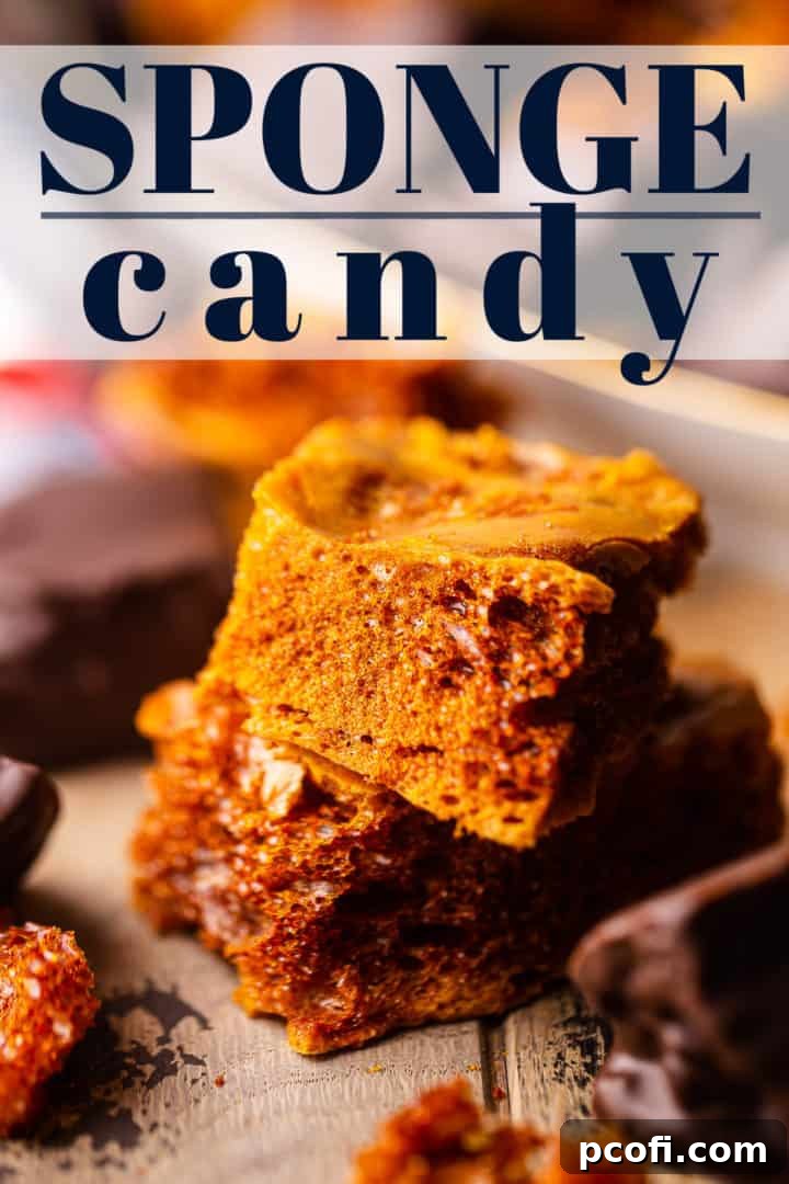 Two pieces of golden honeycomb candy stacked on a rustic surface, highlighting its airy texture.