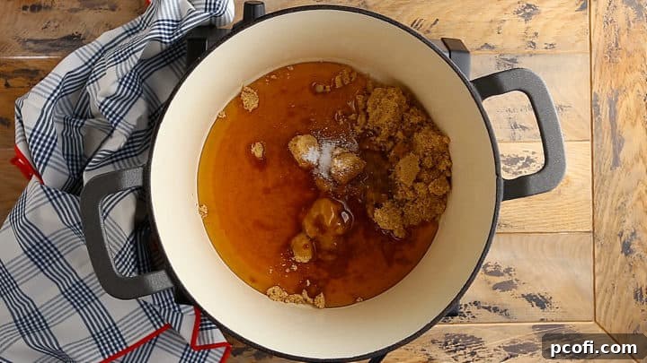 Brown sugar, honey, vinegar, and salt are added to an enameled cast iron pot, ready to be cooked into sponge candy.