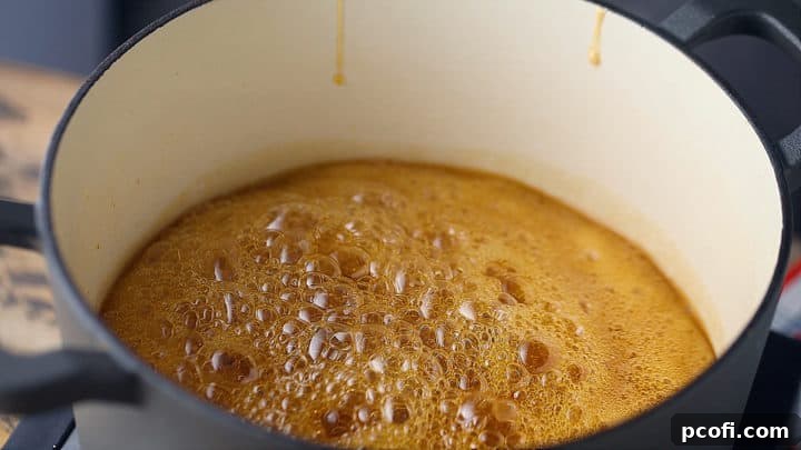 Boiling sugar mixture in a large pot, showing the caramelization process for sponge candy.