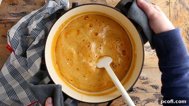 Baking soda is whisked into the hot sugar mixture, causing it to foam up and expand rapidly, forming the airy sponge candy texture.