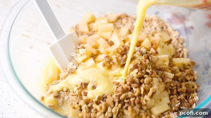 Adding liquid ingredients to dry for baked oatmeal, a crucial step in preparing this easy breakfast casserole.