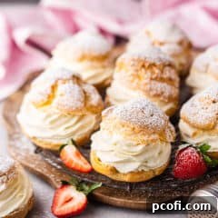 Classic cream puff on a wire rack with strawberries.