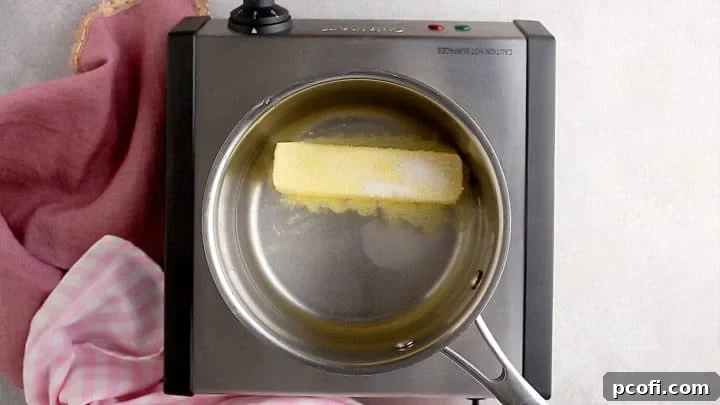 Water, butter, sugar, and salt simmering together in a small pot for choux pastry base.