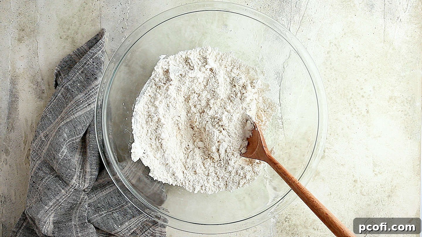 Flour, salt, yeast, and warm water in a large glass mixing bowl.