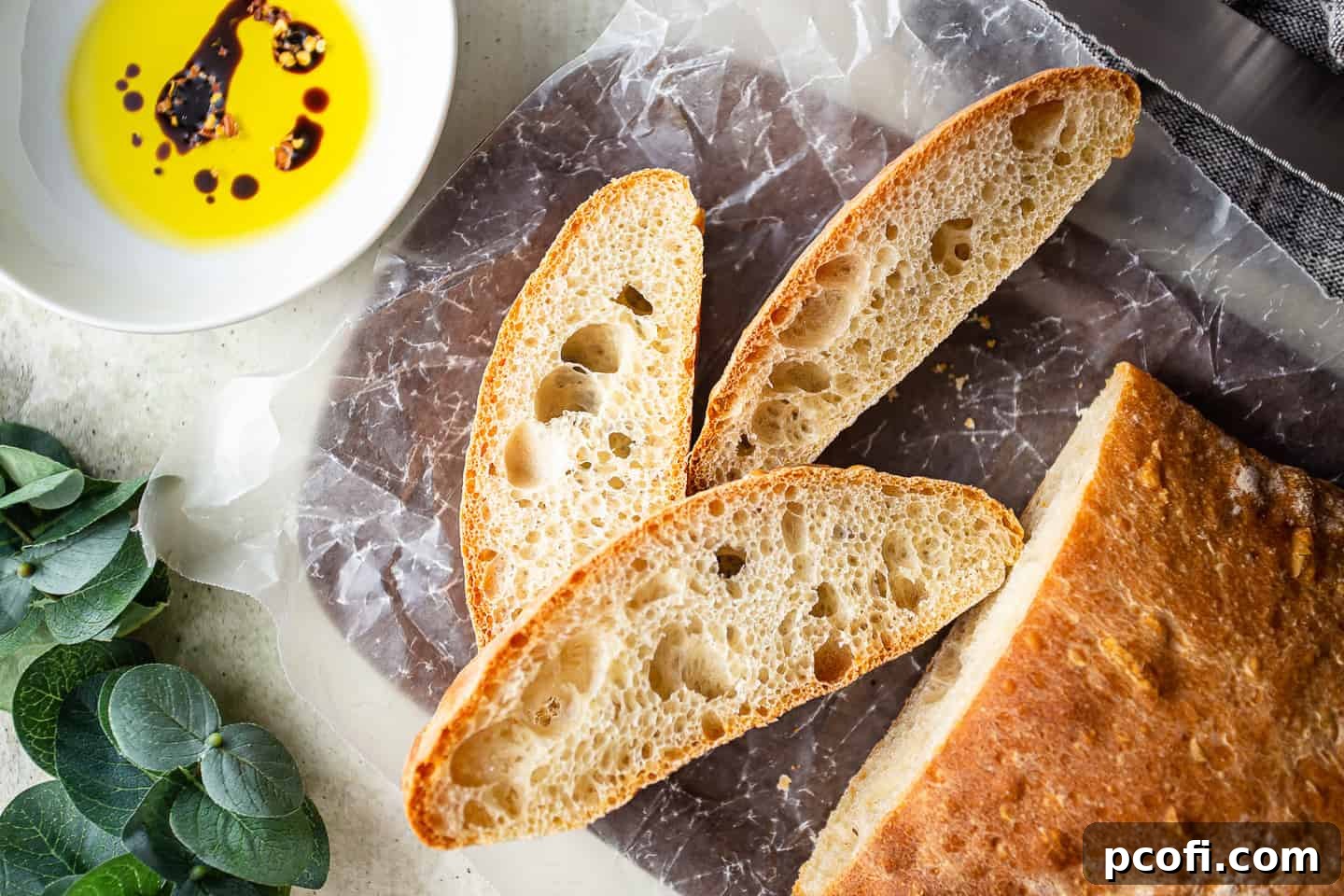 Ciabatta bread recipe, prepared and presented on a wooden board with greenery.