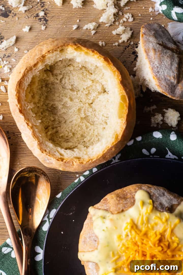 Overhead image of two bread bowls, one filled with soup and the other scooped out and empty.