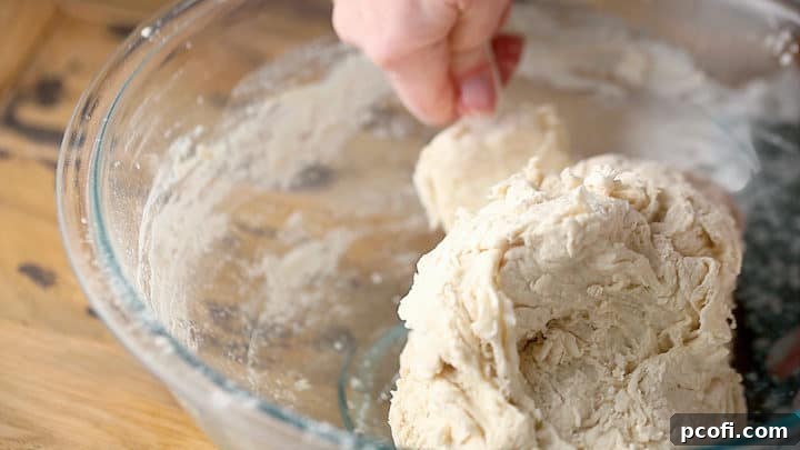Mixing stiff bread dough with a silicone spatula.