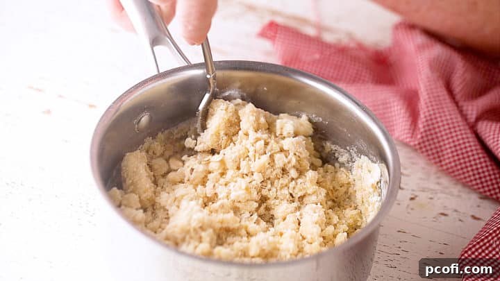 Stirring the crumb topping mixture with a fork until perfectly crumbly.