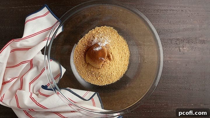 Dry ingredients for the graham cracker crust in a large glass bowl, ready for mixing.