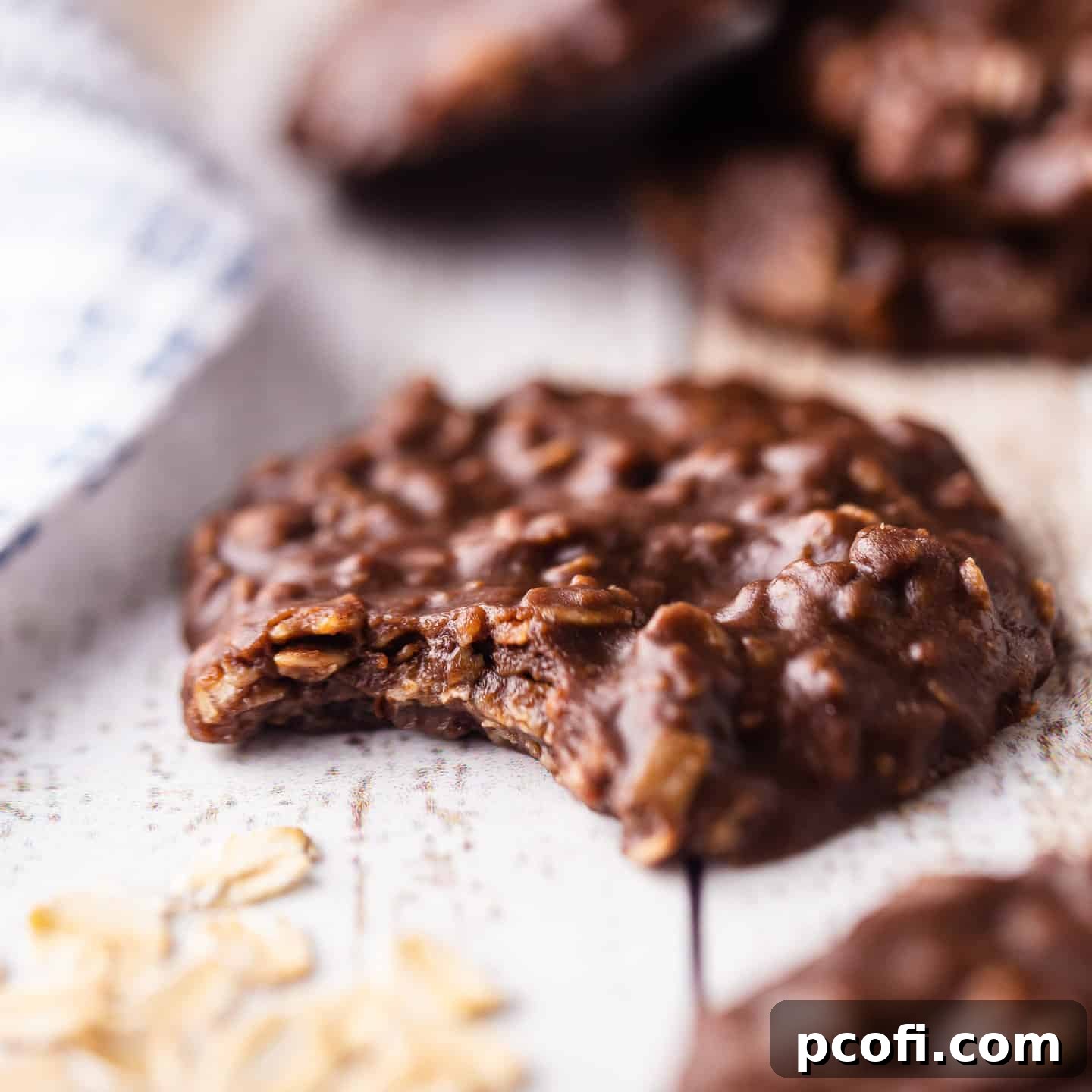 Delicious no-bake chocolate peanut butter oatmeal cookie with a bite taken out, showing its fudgy texture.