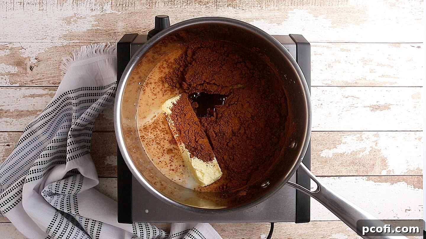 Sugar, milk, butter, and cocoa powder gently heating in a saucepan on the stovetop.