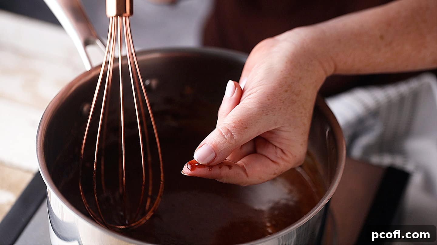 A cook tests the sugar dissolution of the no-bake cookie mixture by rubbing a drop between fingers.