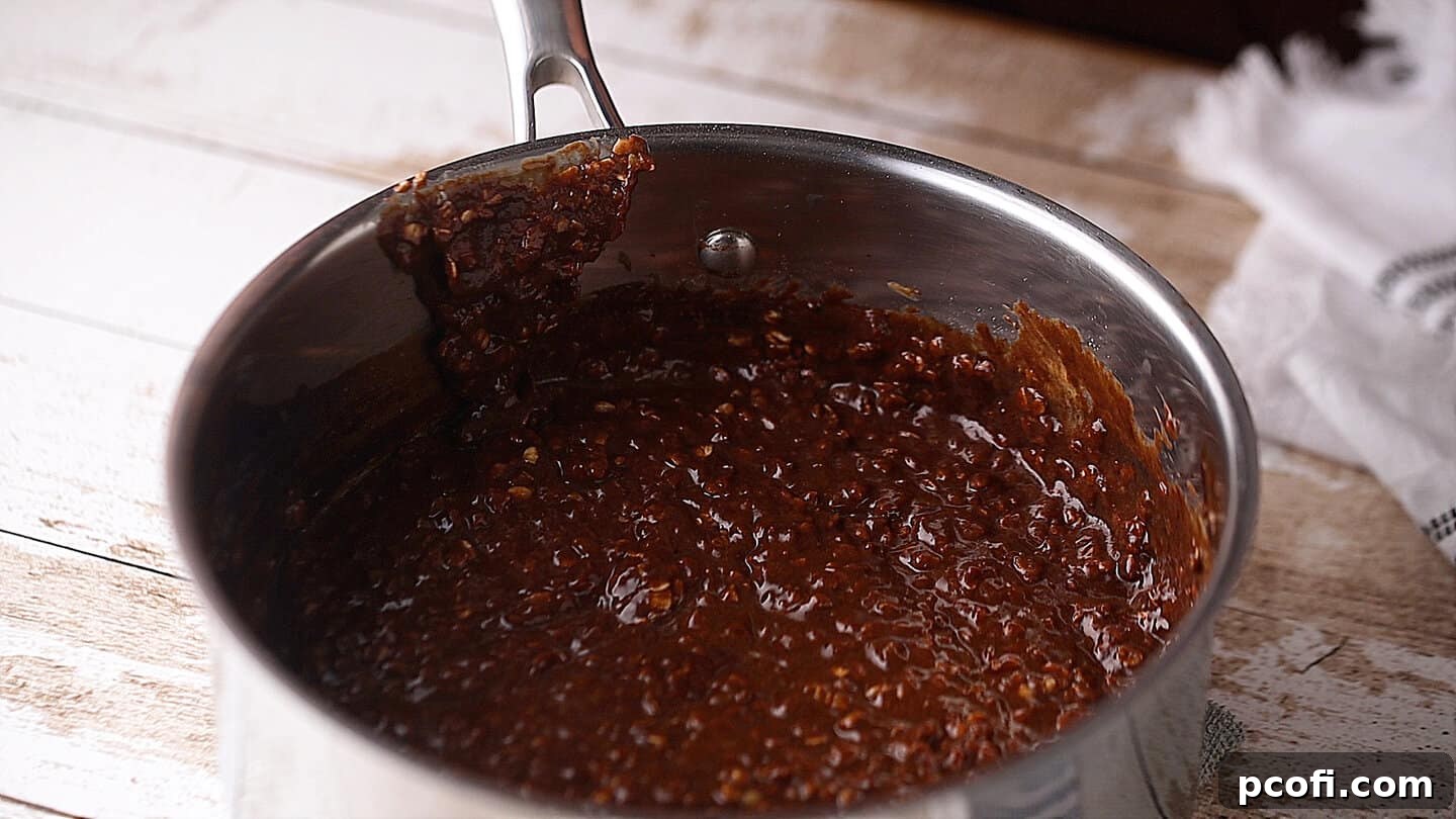 Thick, rich no-bake cookie batter after mixing in oats and peanut butter, still in the pot.