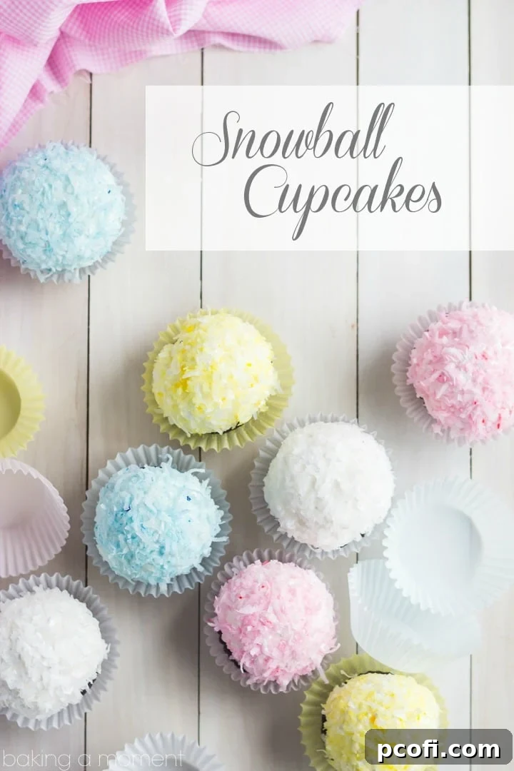 A stunning close-up of our pastel coconut snowball cupcakes. Each fluffy marshmallow cloud sits atop a rich chocolate cupcake, delicately adorned with colorful coconut flakes.