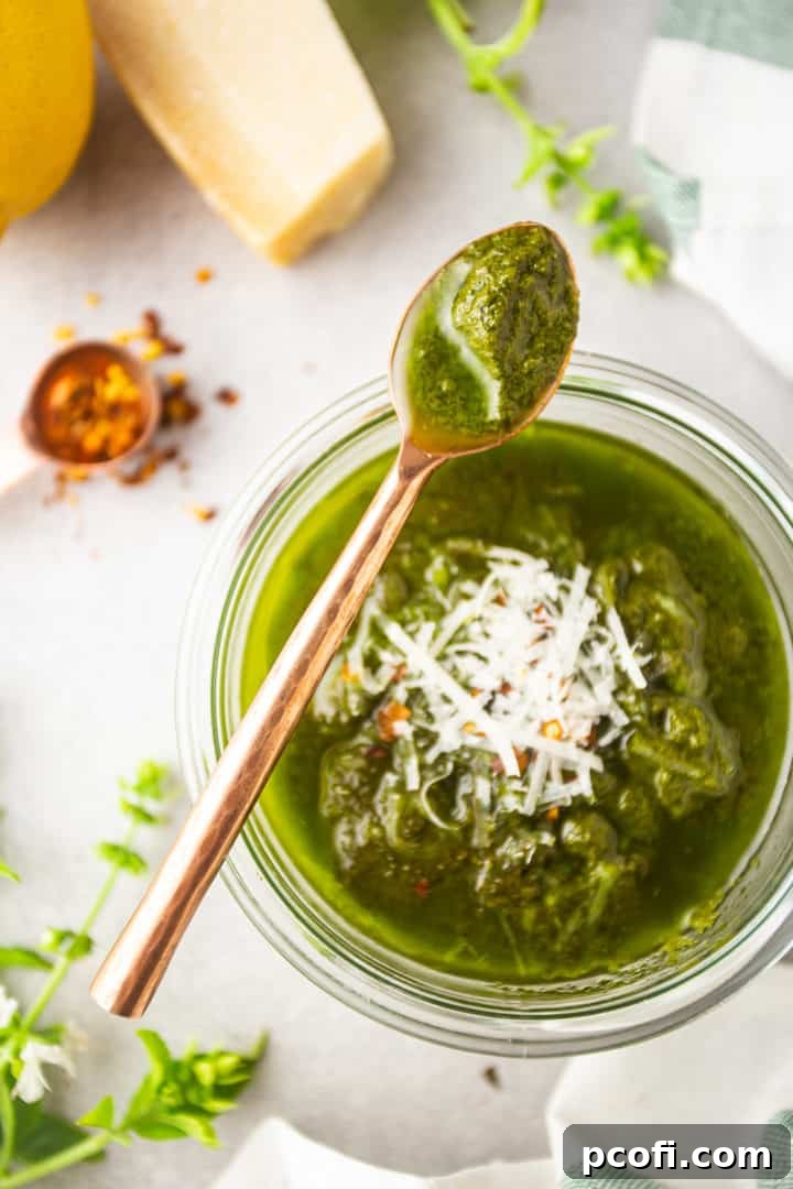 Pesto pasta sauce spooned from the jar with a copper spoon.