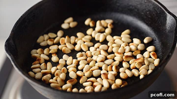Toasted pine nuts in a cast iron skillet.