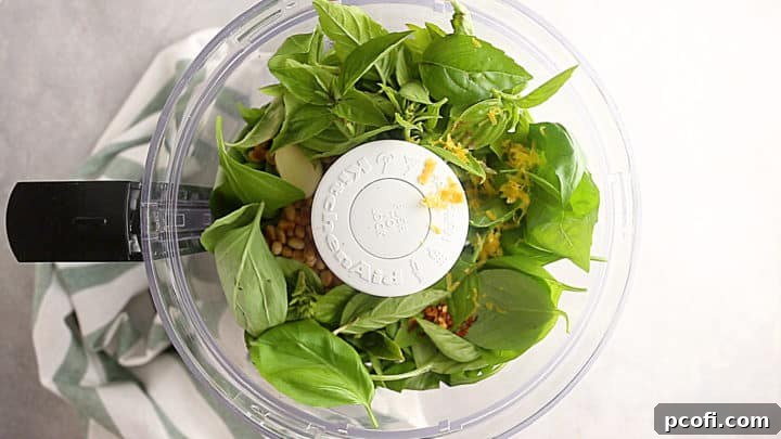 Pesto ingredients in the bowl of a food processor.