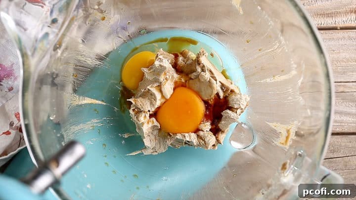 Adding eggs and vanilla to brown sugar cookie dough.