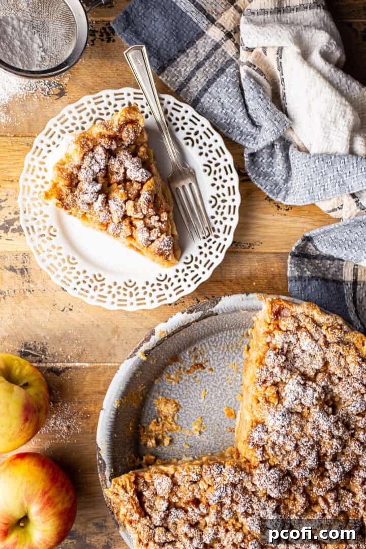 Overhead image of Dutch apple pie served on a distressed wooden surface, showcasing its rustic charm and delicious crumb topping.