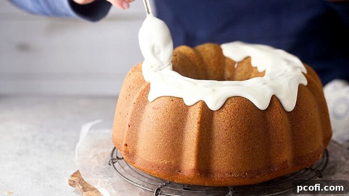 Icing a pumpkin bundt cake with cream cheese glaze.